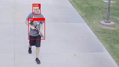 AI surveillance tracking systems identifying a gun and mask on an individual.
